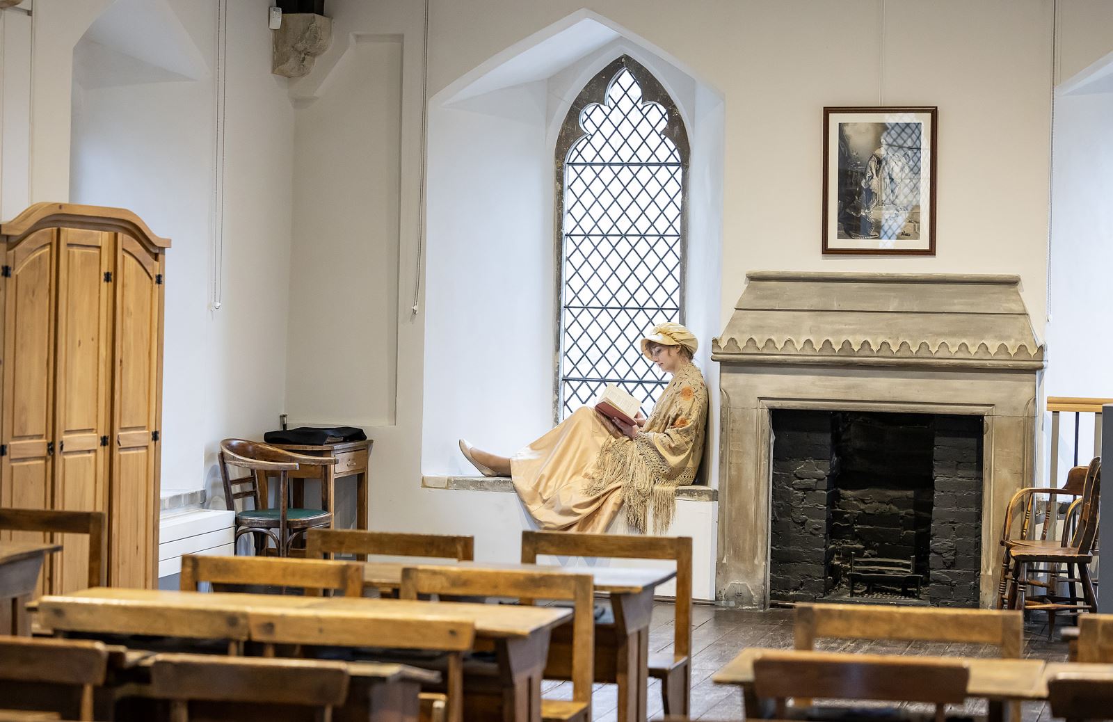 Lady dressed as Jane Austen sitting in the window of Reading Ladies School school room in Reading